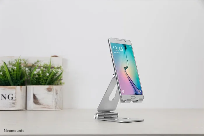 Neomounts DS10-160SL1 Soporte plegable para smartphone de escritorio, hasta 7" con ajuste de inclinación 270°, aluminio plateado, ideal para videollamadas y películas