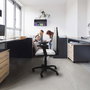 Chaise de bureau Algarra avec mécanisme de contact permanent de base, rembourrée de tissu noir. Équipée d'une base en polyamide noir, d'accoudoirs 2D et de roulettes pour parquet.