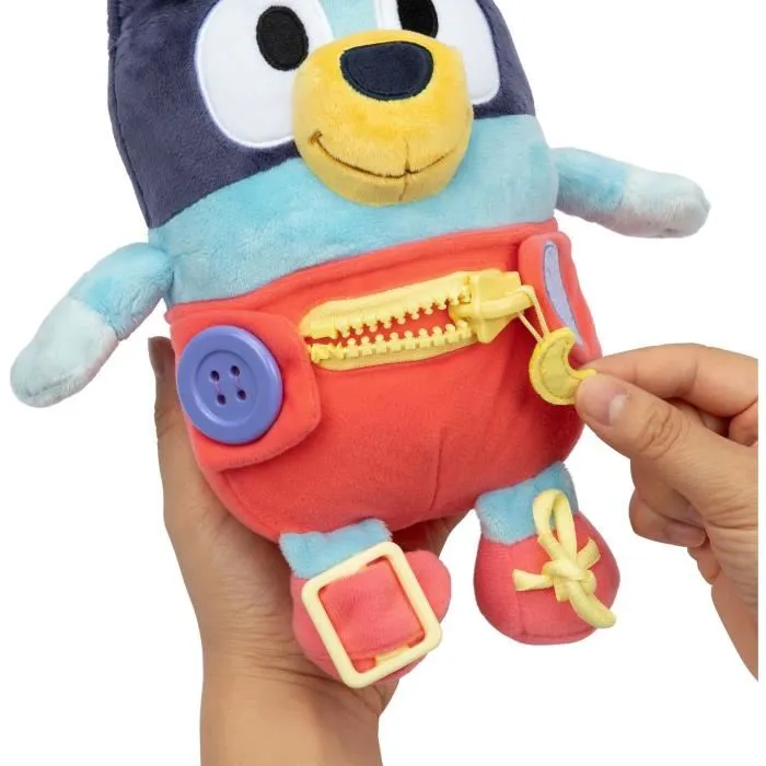 Bluey Peluche d'éveil et d'activités Bébé avec fermetures à lacets, boutons et zip pour apprendre l'habillement et la motricité fine - 25 cm