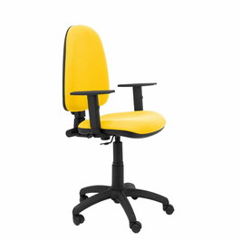 Chaise de bureau Aýna avec mécanisme Contact permanent de base, revêtue de tissu jaune. Équipée d'une base en polyamide noir, d'accoudoirs 1D et de roulettes en nylon de 50 mm.