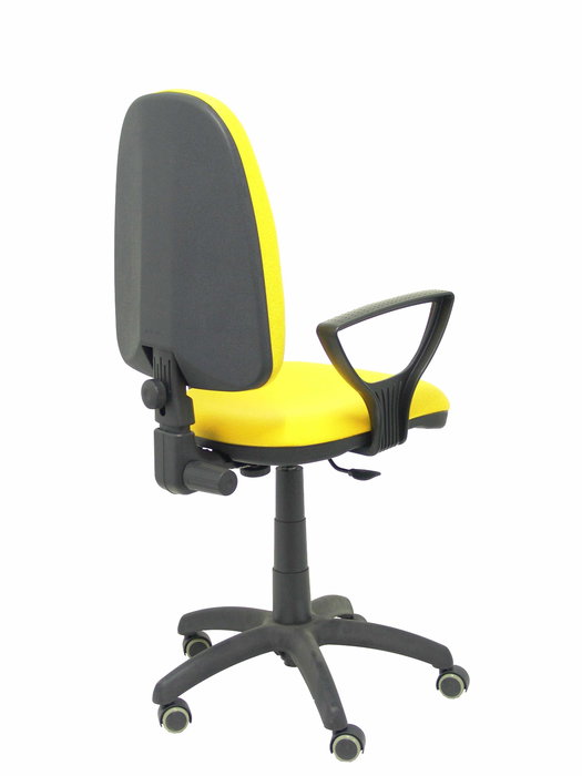Chaise de bureau Aýna avec mécanisme Contact permanent de base, revêtue de tissu jaune. Équipée d'une base en polyamide noir, d'accoudoirs fixes et de roulettes pour parquet