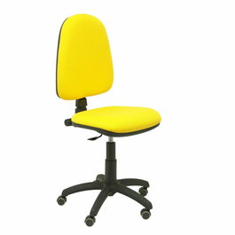 Chaise de bureau Aýna avec mécanisme Contact permanent de base, revêtue de tissu jaune. Équipée d'une base en polyamide noir, sans accoudoirs et avec roulettes pour parquet.